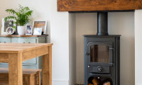 A photo of a cosy lounge with log burning fireplace