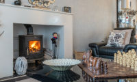 A photo of a cosy lounge with log burning fireplace